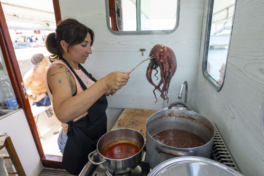 Silvia nella cucina di bordo controlla la cottura del polpo nella pentola